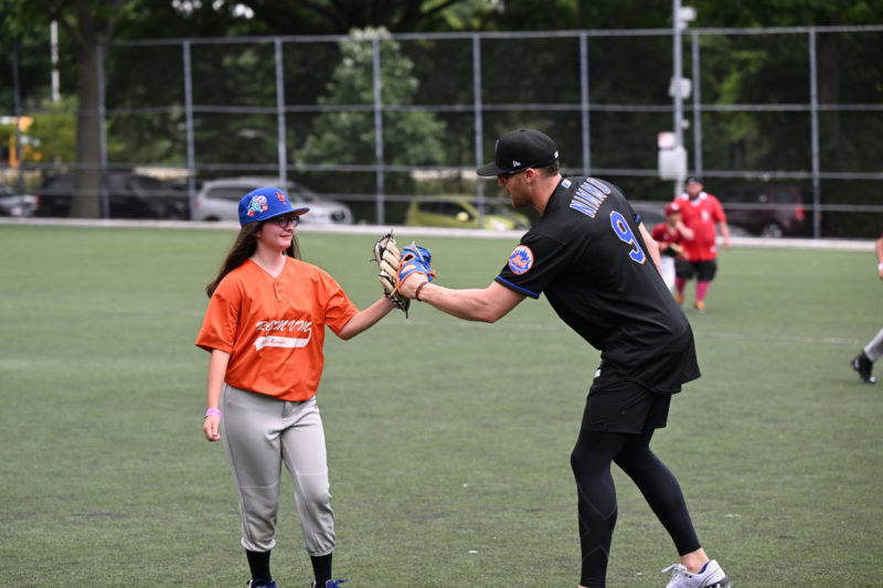 older baseball player touching glove of younger player